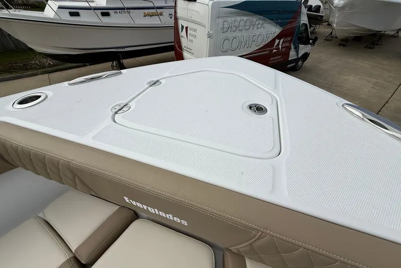Slide: The Image of 2026 Everglades 315 Center Console boat deck with beige seating and storage compartments. - 25