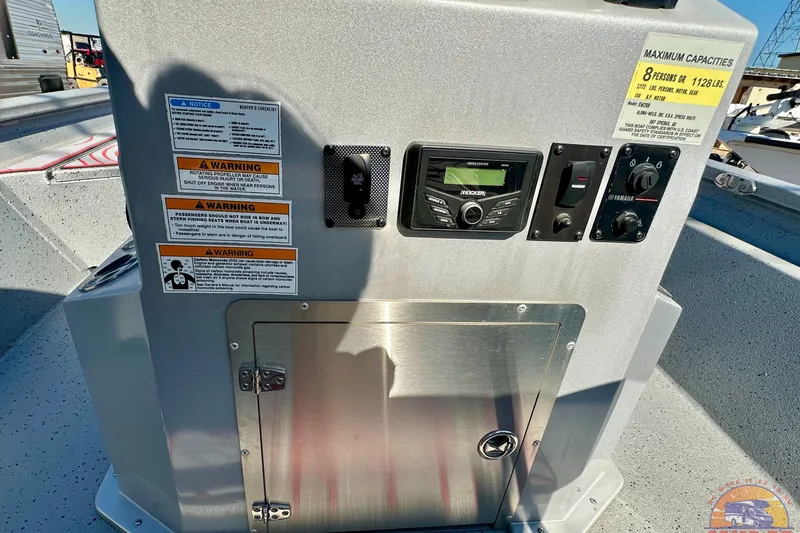 Slide: The Image of 2024 SeaArk SW20B BAY boat console with controls, warning labels, and capacity information. - 17