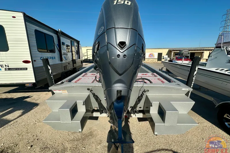 Slide: The Image of 2024 SeaArk SW20B BAY boat with powerful outboard motor, parked beside a camper. - 6