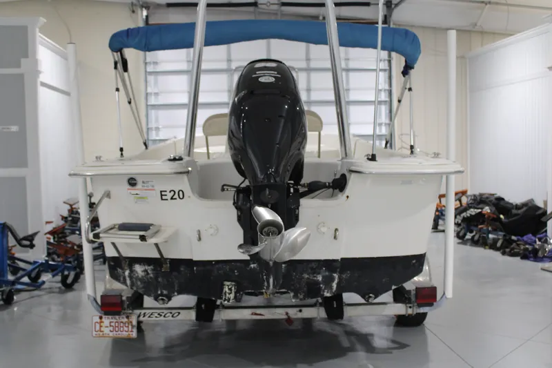 Slide: The Image of 2014 Carolina Skiff 198 DLV boat in garage, rear view with motor and trailer. - 7
