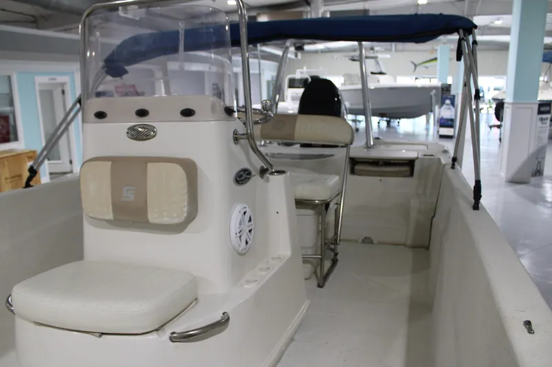 Slide: The Image of 2014 Carolina Skiff 198 DLV boat interior with seating and console in showroom. - 9