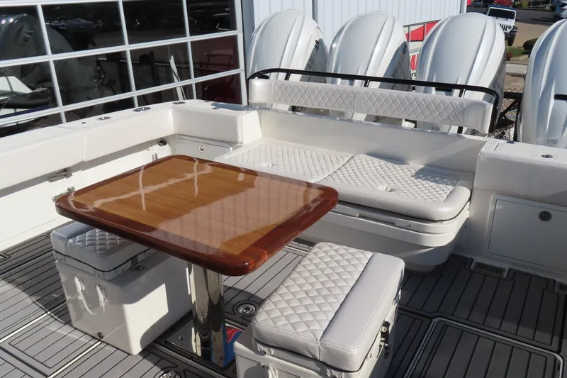 Slide: The Image of Luxury seating area on 2018 HCB 53 boat with quilted cushions and wooden table. - 14