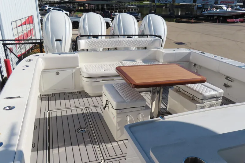 Slide: The Image of 2018 HCB 53 boat deck with seating, table, and four powerful outboard engines. - 17