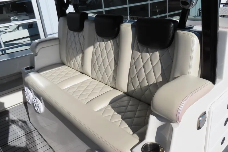 Slide: The Image of Luxurious seating on 2018 HCB 53 boat with diamond-stitched upholstery and cup holders. - 19