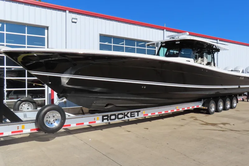 Slide: The Image of 2018 HCB 53 boat on trailer outside a building, sunny day. - 2