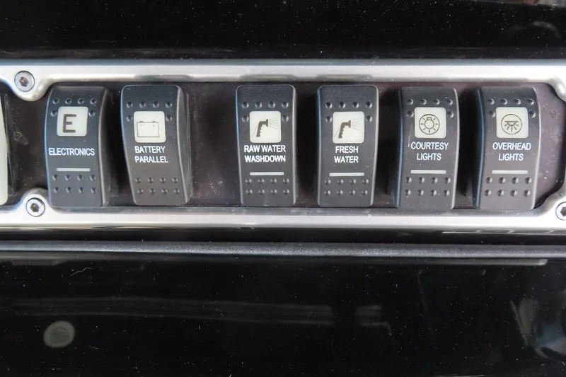 Slide: The Image of Control panel switches on a 2018 HCB 53 boat dashboard. - 23