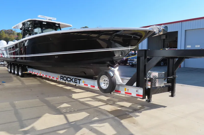 Slide: The Image of 2018 HCB 53 boat on Rocket trailer, parked outside a garage. - 3