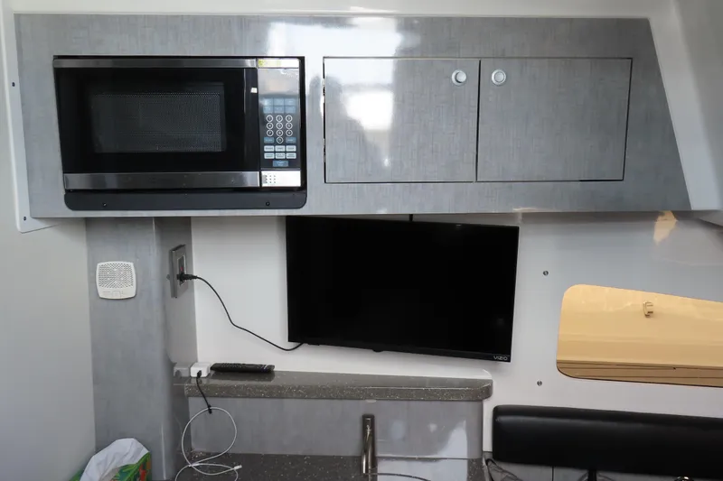Slide: The Image of Interior of 2018 HCB 53 boat with microwave, TV, and storage cabinets. - 44