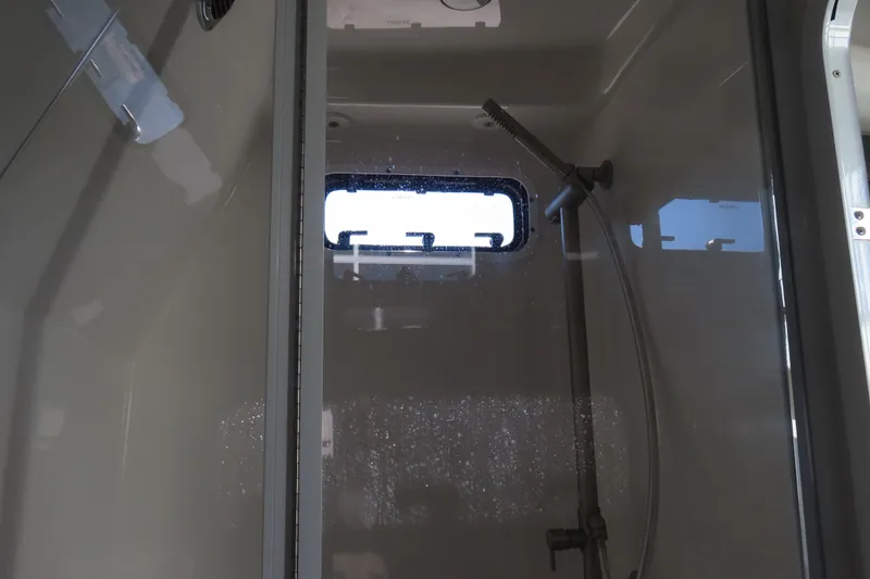 Slide: The Image of Interior of 2018 HCB 53 boat shower with window and handheld showerhead. - 48