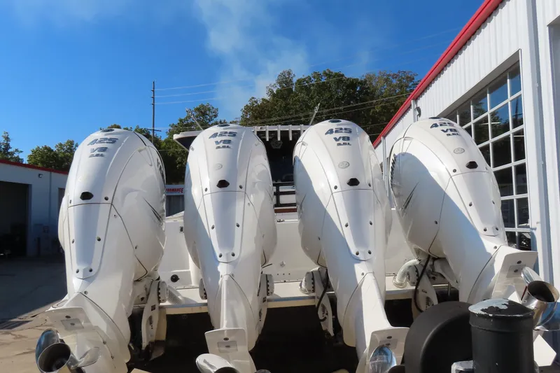Slide: The Image of Four powerful outboard motors on a 2018 HCB 53 boat, parked near a garage. - 6