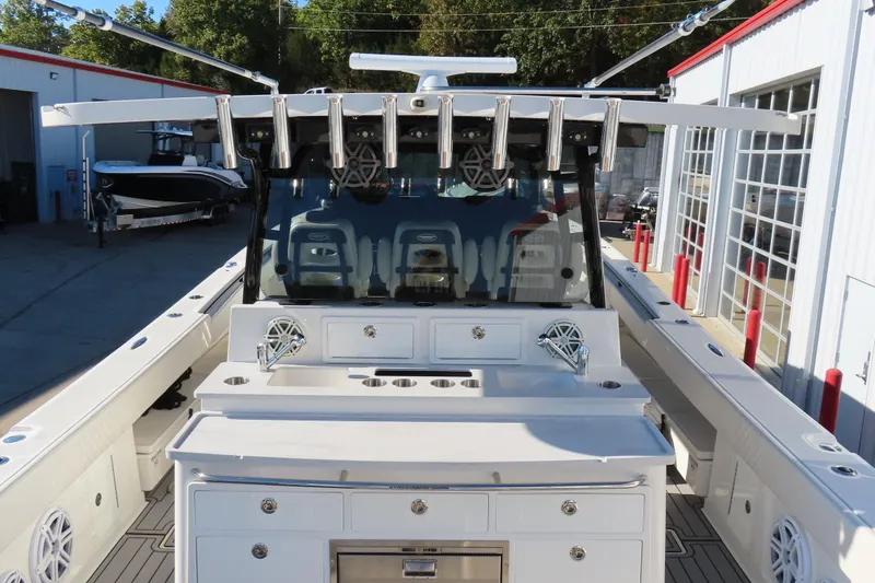 Slide: The Image of 2018 HCB 53 boat with fishing rod holders and storage compartments, docked at a marina. - 9