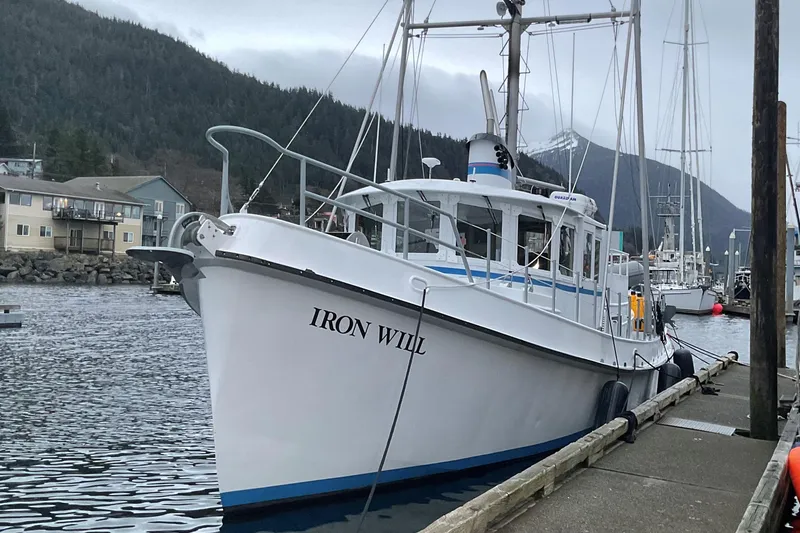 Slide: The Image of Custom 2006 Sprague boat "Iron Will" docked in a scenic harbor with mountains. - 1