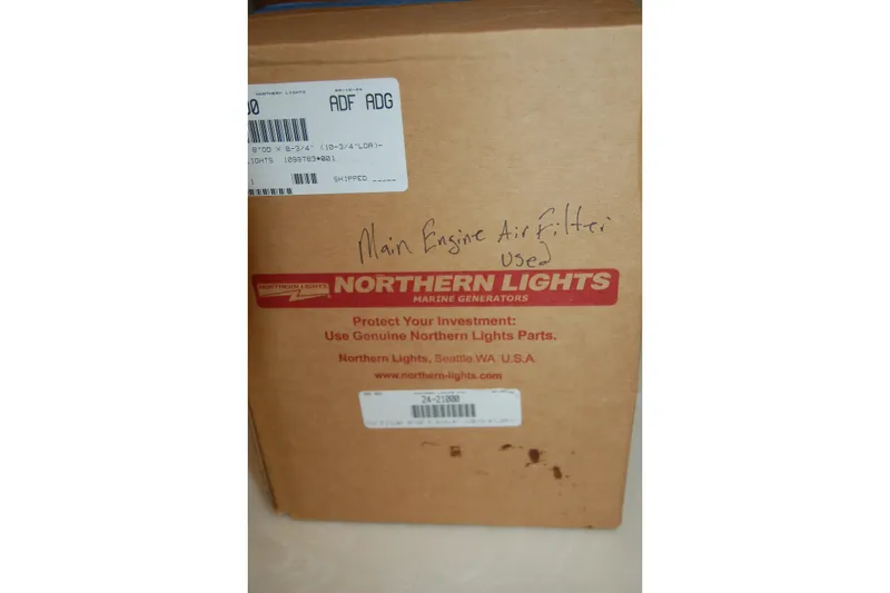 Slide: The Image of Cardboard box labeled "Northern Lights Marine Generators" with handwritten note "Main Engine Air Filter Used." - 107