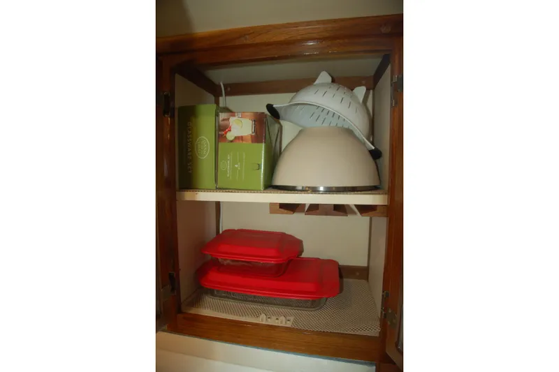 Slide: The Image of Kitchen cabinet with cookware, colander, and storage containers, Custom Sprague 2006 model. - 112
