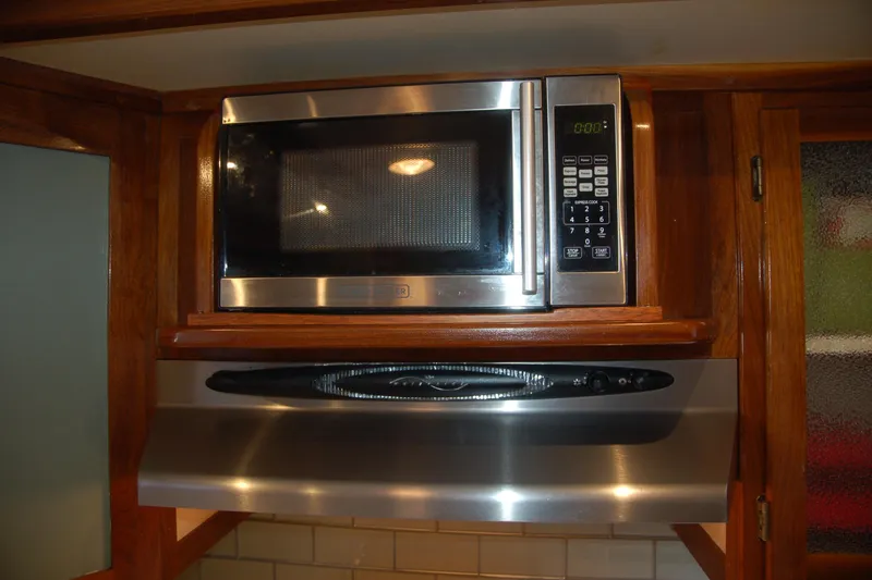 Slide: The Image of Stainless steel microwave and range hood in wooden kitchen cabinetry, Custom Sprague 2006 model. - 113