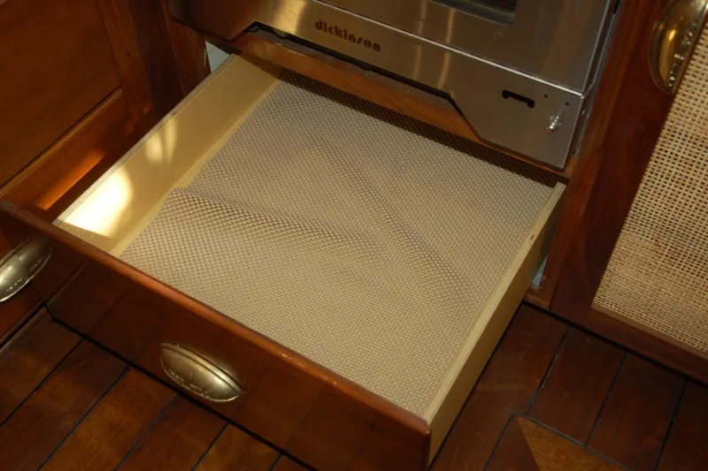 Slide: The Image of Open wooden drawer with non-slip liner, beneath a stainless steel appliance, Custom Sprague 2006 model. - 116