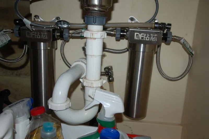 Slide: The Image of Under-sink water filtration system with pipes and cleaning supplies, Custom Sprague 2006 model. - 126