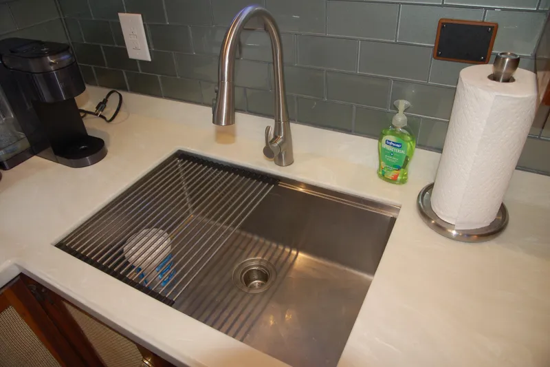 Slide: The Image of Modern kitchen sink with stainless steel faucet, paper towel holder, and soap dispenser. Custom Sprague 2006. - 127