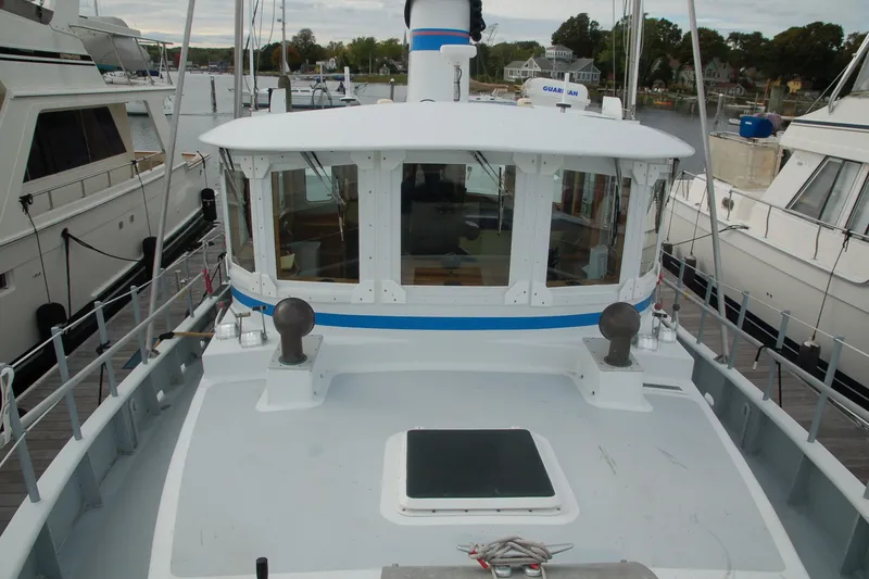 Slide: The Image of Custom 2006 Sprague boat docked, featuring a white and blue cabin with surrounding yachts. - 13