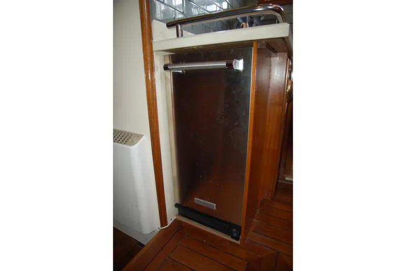 Slide: The Image of Custom 2006 Sprague refrigerator with wooden paneling and stainless steel door in a compact space. - 130