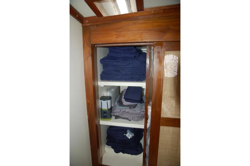 Slide: The Image of Wooden cabinet with neatly stacked blue and gray towels, Custom Sprague 2006 model. - 142