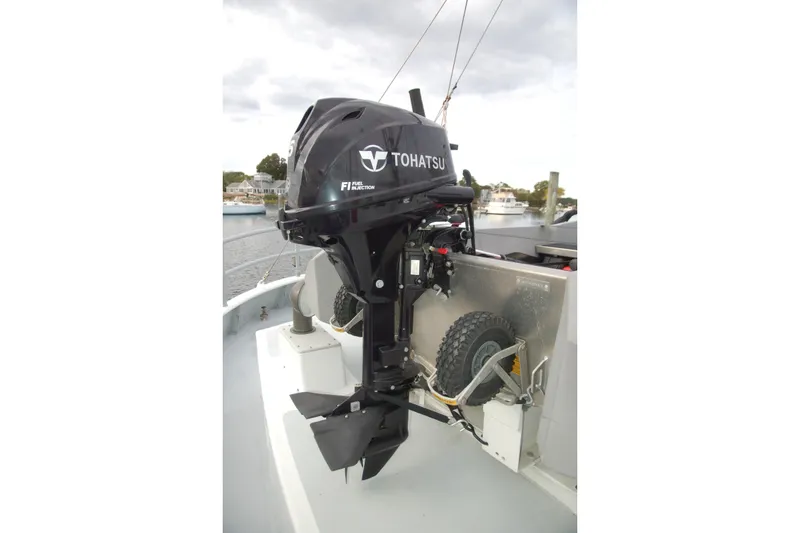 Slide: The Image of Tohatsu outboard motor on a 2006 Custom Sprague boat, docked by the water. - 154