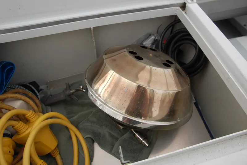 Slide: The Image of Storage compartment with metal dome, cables, and tools in a 2006 Custom Sprague. - 167