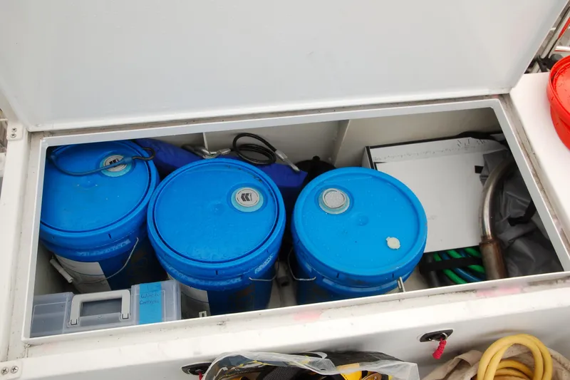 Slide: The Image of Storage compartment with blue buckets and equipment in a 2006 Custom Sprague model. - 171