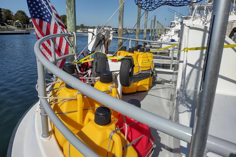 Slide: The Image of Boat deck with yellow fuel containers, American flag, and docked vessels in the background. Custom Sprague 2006. - 174