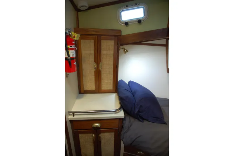 Slide: The Image of Cozy cabin interior with wooden cabinets, bed, and fire extinguisher on a 2006 Custom Sprague. - 32