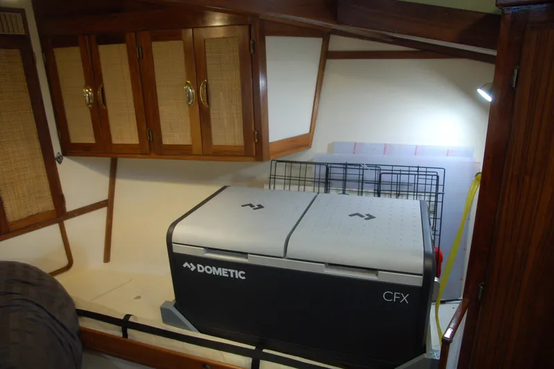 Slide: The Image of Compact cabin interior with Dometic CFX cooler, wooden cabinets, and ambient lighting. - 33