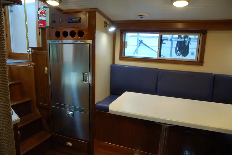 Slide: The Image of Cozy boat interior with stainless steel fridge, blue seating, and white table, Custom Sprague 2006. - 51
