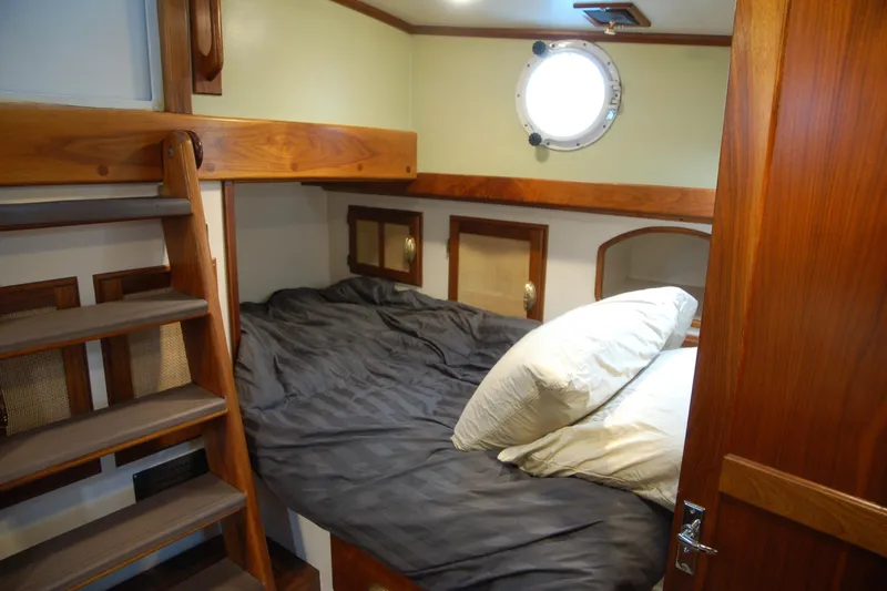 Slide: The Image of Cozy cabin interior with wooden accents, Custom Sprague 2006 model, featuring a bed and porthole. - 58