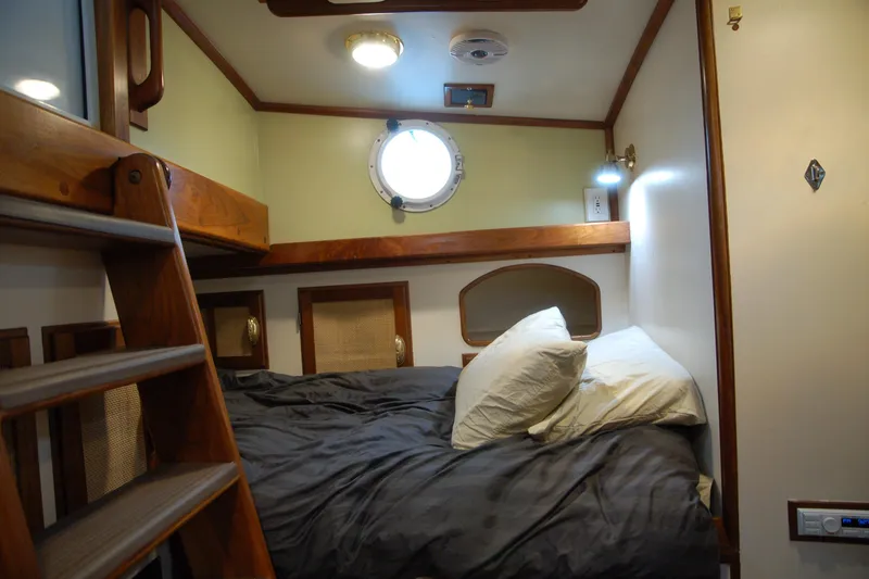 Slide: The Image of Cozy Custom Sprague 2006 boat cabin with bed, porthole, and wooden ladder. - 60