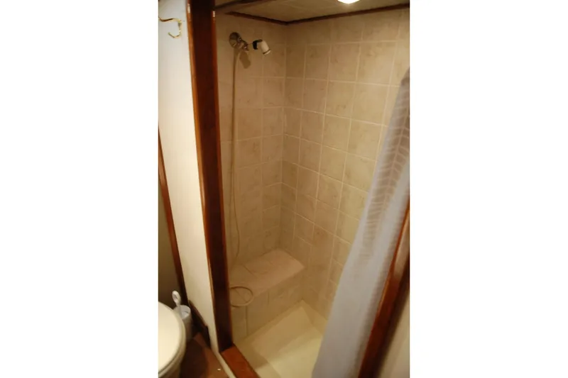 Slide: The Image of Compact tiled shower in 2006 Custom Sprague model, featuring a built-in seat and curtain. - 64