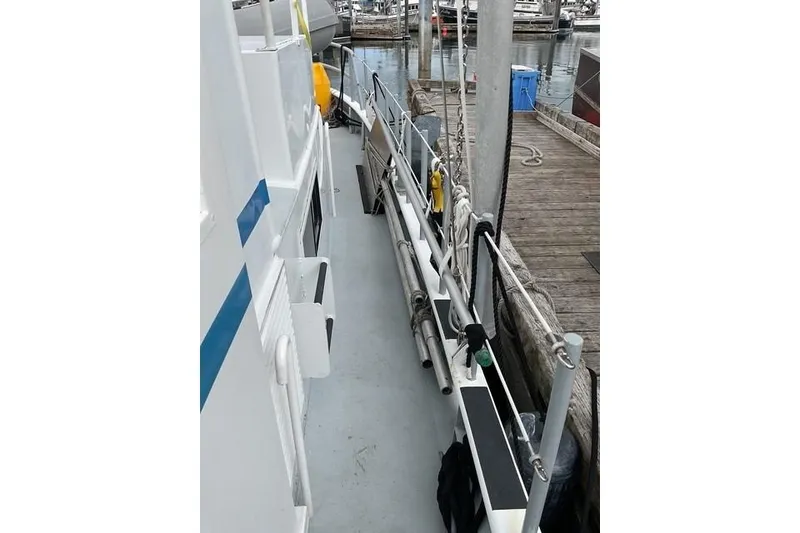 Slide: The Image of Custom Sprague 2006 boat deck with dockside view, featuring railings and equipment. - 7