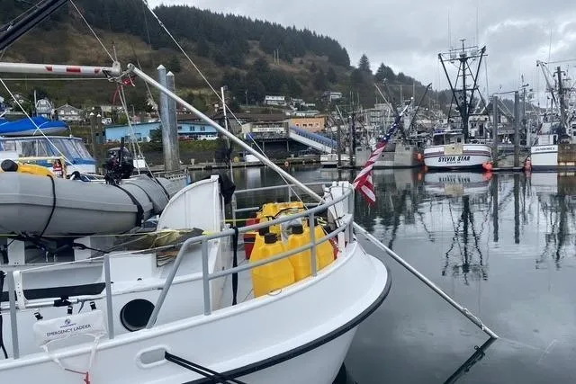 Slide: The Image of Custom Sprague 2006 boat docked in a scenic harbor with fishing vessels. - 8