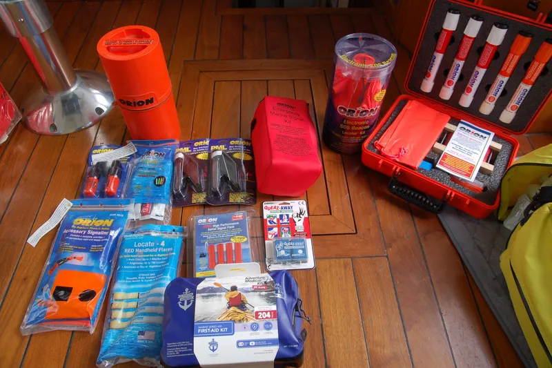 Slide: The Image of Safety equipment and emergency kits on wooden surface, including flares and first aid supplies. - 94