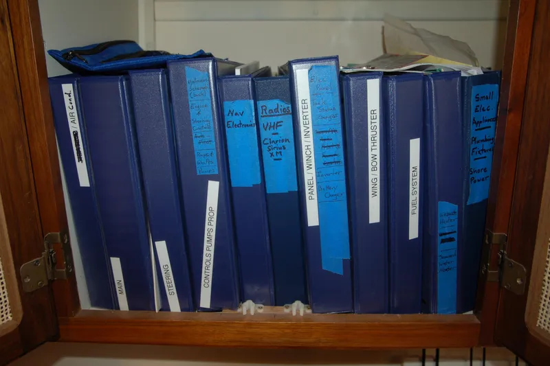 Slide: The Image of Blue binders labeled with technical categories in a wooden cabinet, Custom Sprague 2006. - 97