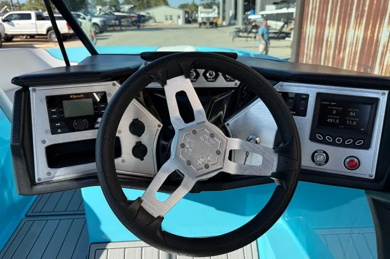 Slide: The Image of 2018 MasterCraft NXT22 boat dashboard with steering wheel and control panels. - 10