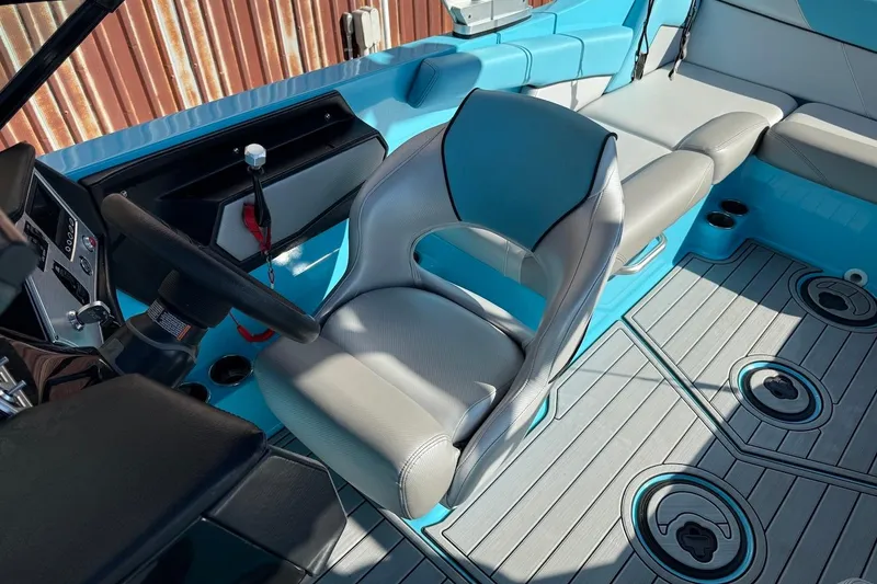 Slide: The Image of 2018 MasterCraft NXT22 boat interior with blue and gray seating and steering wheel. - 14
