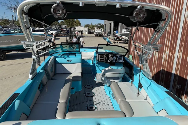 Slide: The Image of 2018 MasterCraft NXT22 boat with blue and gray interior, docked outdoors. - 4