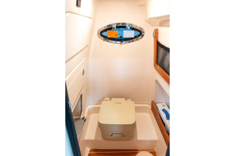 Slide: The Image of 2025 Grady-White 251 Coastal Explorer boat interior with compact marine toilet. - 21