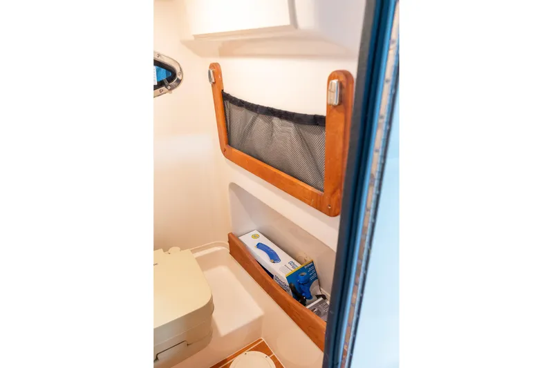 Slide: The Image of 2025 Grady-White 251 Coastal Explorer interior storage with mesh pocket and shelf. - 22