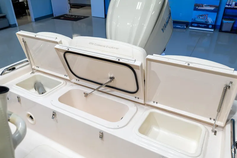 Slide: The Image of 2025 Grady-White 251 Coastal Explorer boat storage compartments open in showroom. - 9