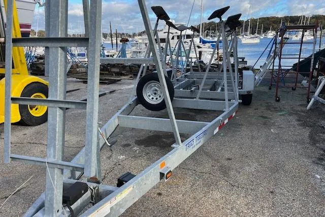 Slide: The Image of Boat trailer for 2017 J Boats J/88, parked near marina with sailboats in background. - 33