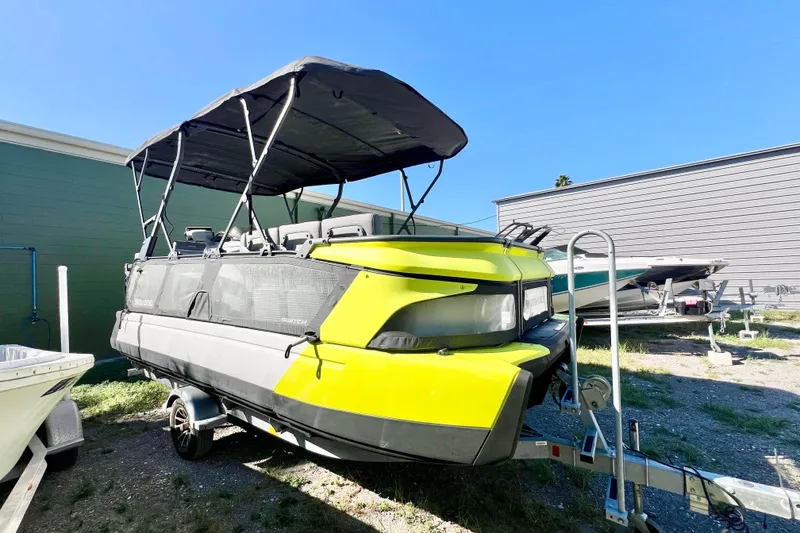 Slide: The Image of 2023 Sea-Doo Switch Cruise 21 pontoon boat with canopy, parked on trailer. - 1
