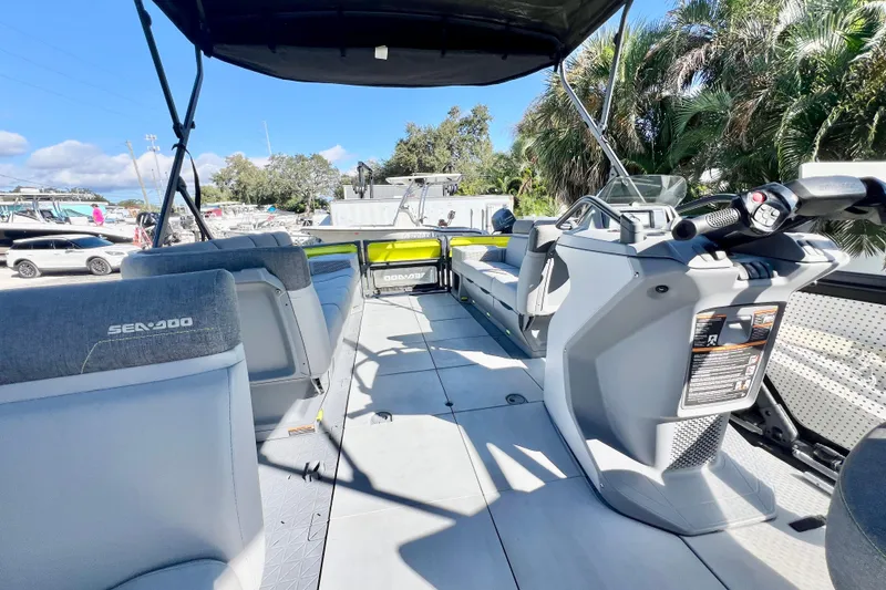 Slide: The Image of 2023 Sea-Doo Switch Cruise 21 interior with seating and controls, docked outdoors. - 14