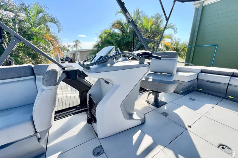 Slide: The Image of 2023 Sea-Doo Switch Cruise 21 interior with modern helm and seating, surrounded by palm trees. - 15