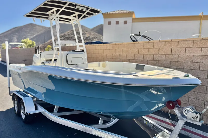 Slide: The Image of 2021 Clearwater 2000 C/C boat on trailer, parked outdoors with mountain backdrop. - 1